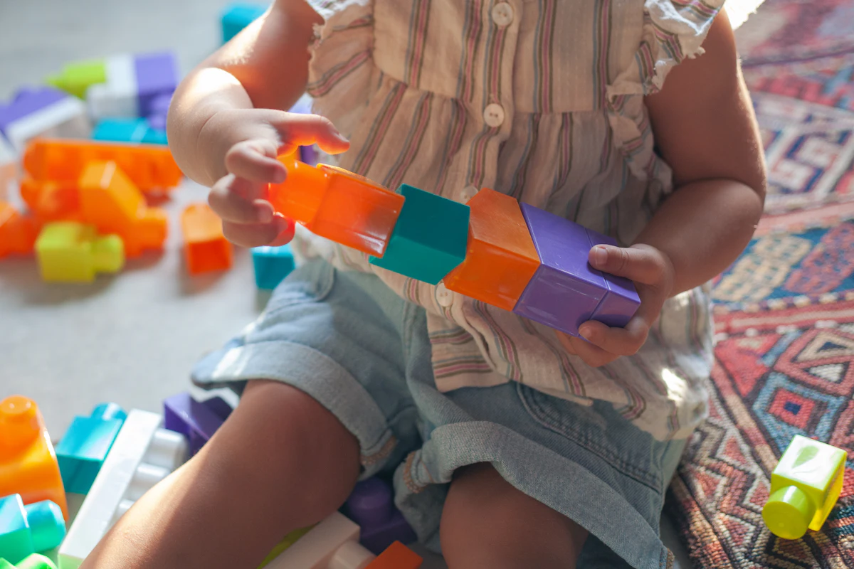 Un enfant assemble des briques de construction colorées
