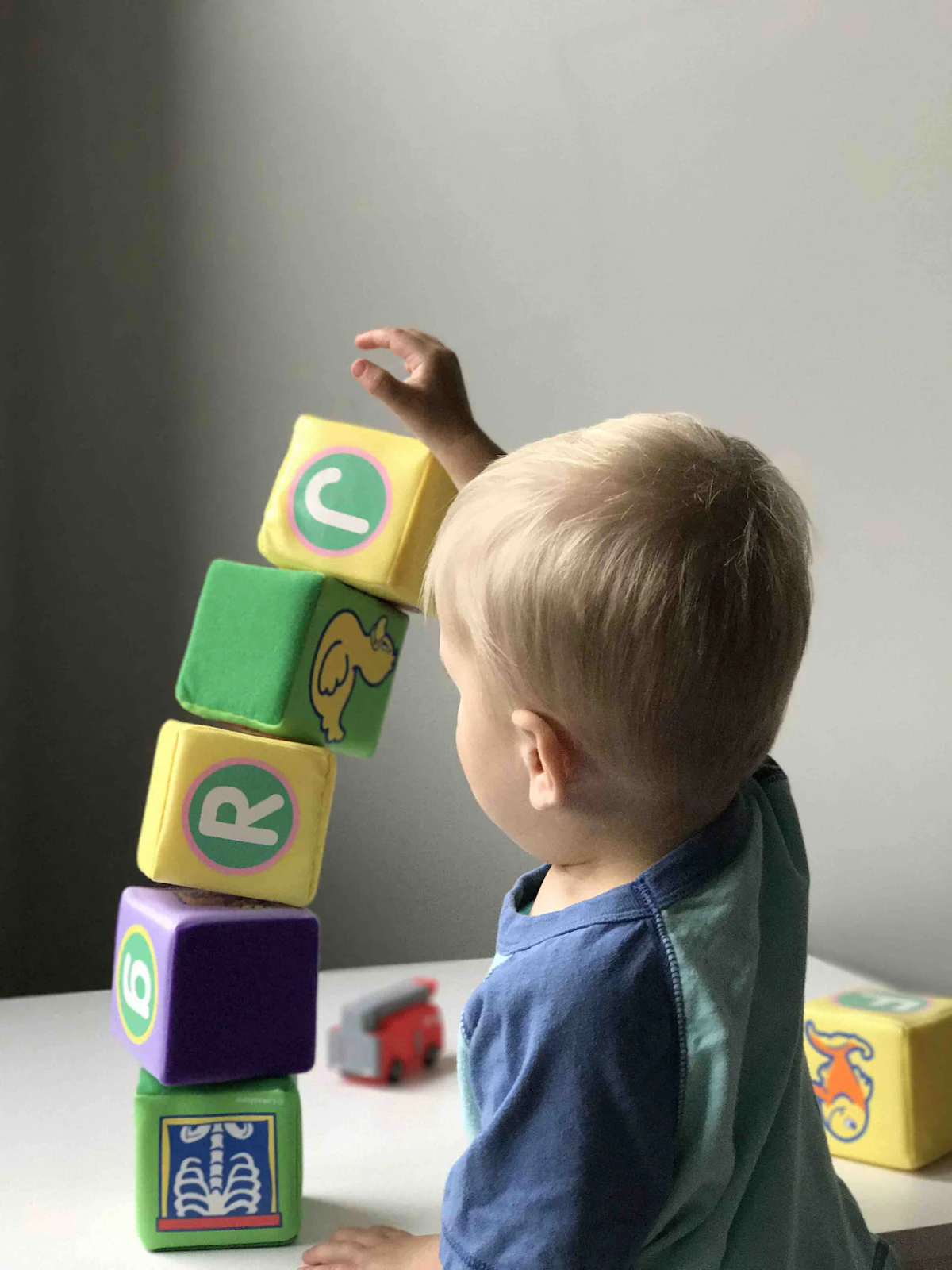 Un petit garçon empile des cubes de couleur